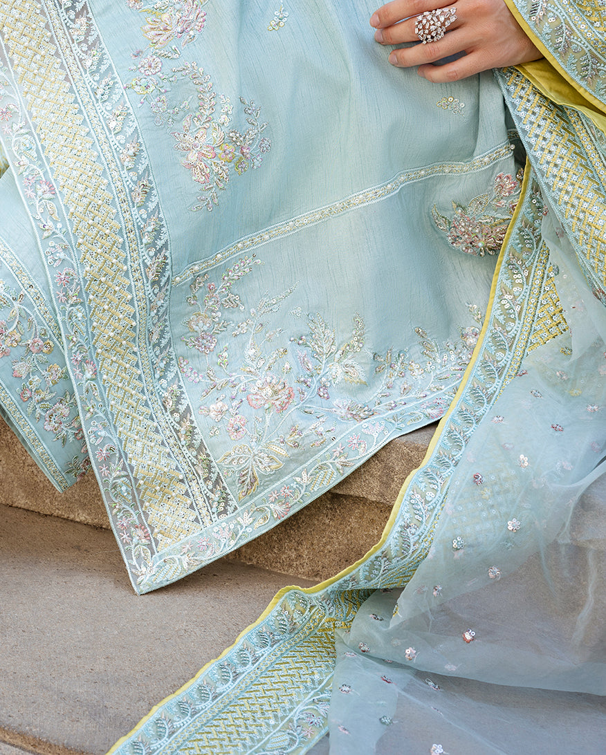 Close-up of embroidered organza dupatta border and floral motifs on icy blue raw silk suit