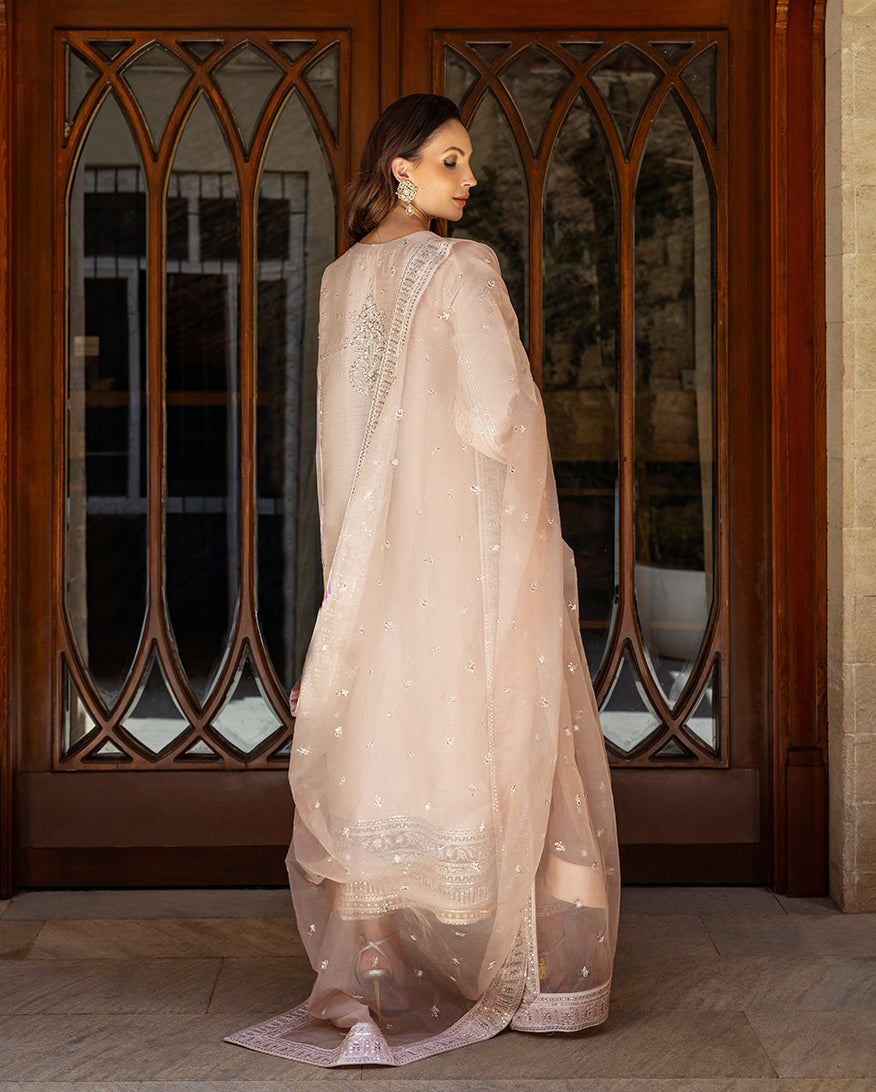 Back view of rose beige raw silk suit with sheer organza dupatta trailing to the floor