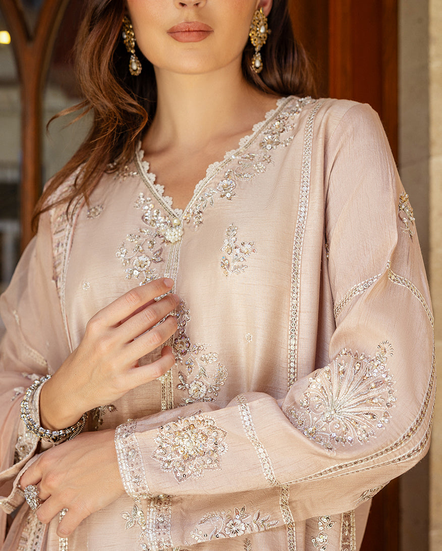 Close-up of hand-embellished neckline and sleeve embroidery on rose beige Korean raw silk shirt