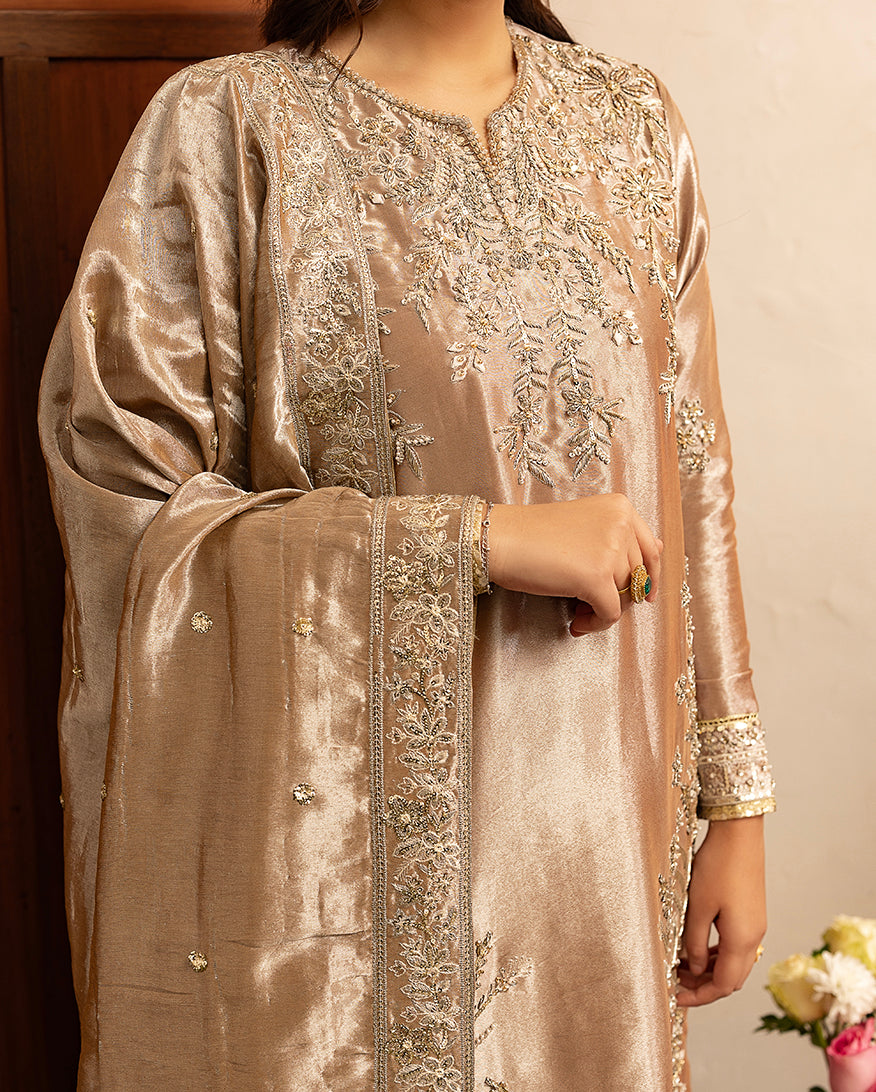 Woman wearing dark beige lama silk suit, close-up of embellished bodice with hand