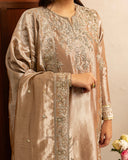 Woman wearing dark beige lama silk suit, close-up of embellished bodice with hand
