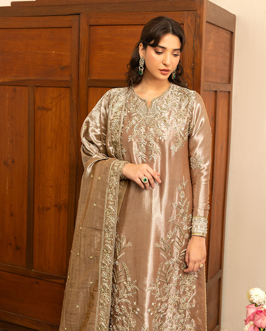Woman wearing dark beige lama silk suit, close-up front, looking down