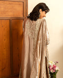 Woman wearing dark beige lama silk suit, back view, side profile, looking down