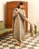 Woman wearing dark beige lama silk suit, front standing, adjusting dupatta, looking down