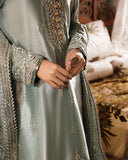 Woman wearing sea green silver zarri silk suit, close-up of embellished sleeve and hands
