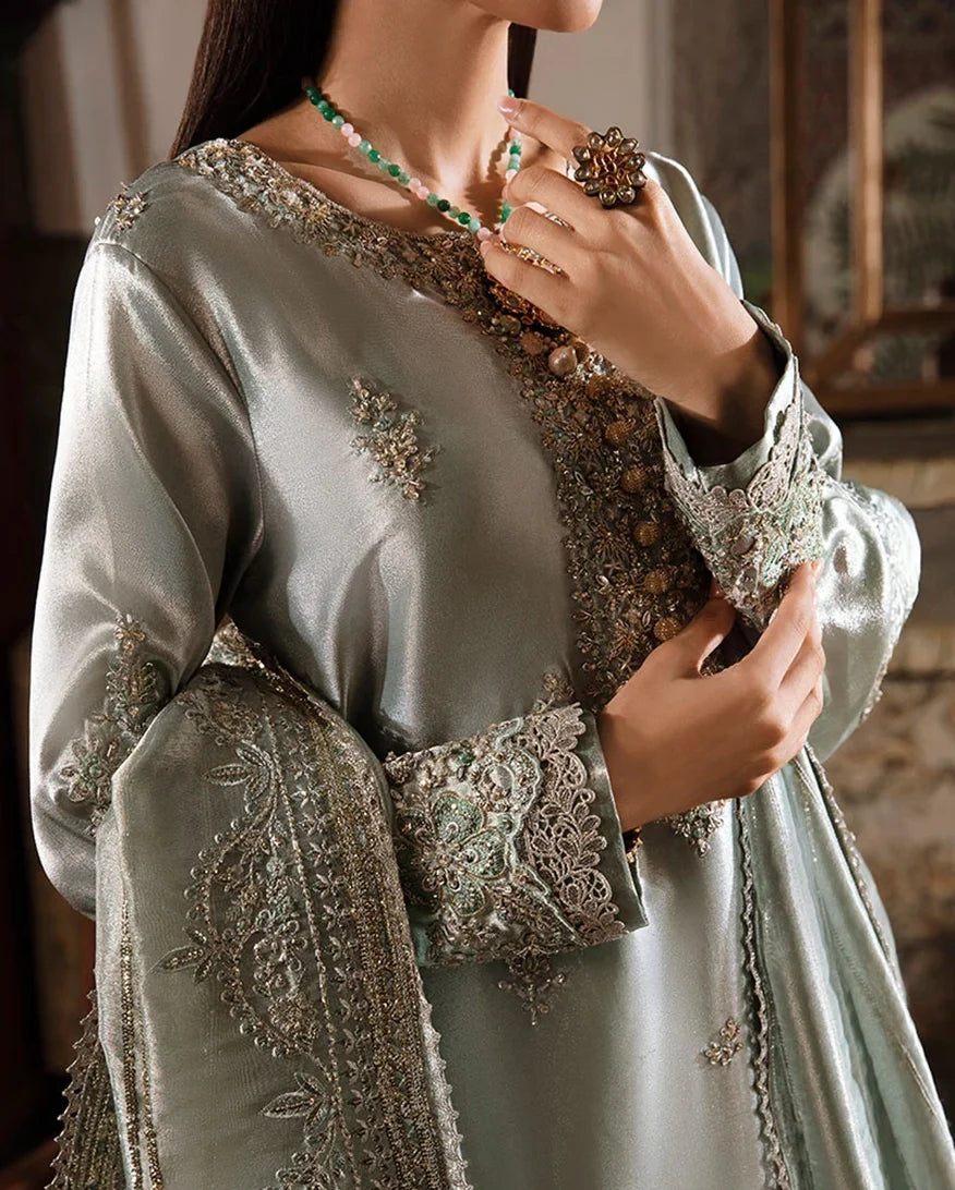 Woman wearing sea green silver zarri silk suit, close-up of embellished bodice with hand at chest