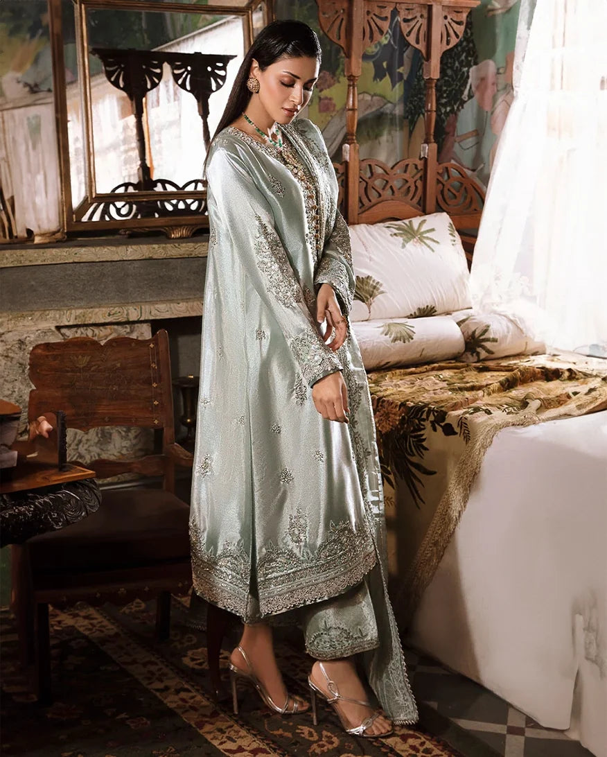 Woman wearing sea green silver zarri silk suit, side standing, looking down