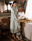 Woman wearing sea green silver zarri silk suit, side standing, looking down