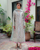 Woman wearing silver embellished satin zari suit, front standing in courtyard