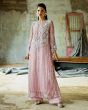 Woman wearing a Powder Pink embroidered Net suit with raw silk trousers
