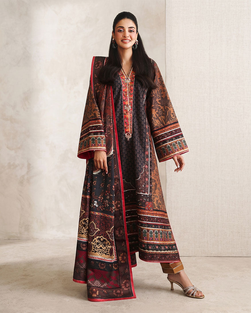 Woman wearing black printed raw silk suit with red trim and striped trouser