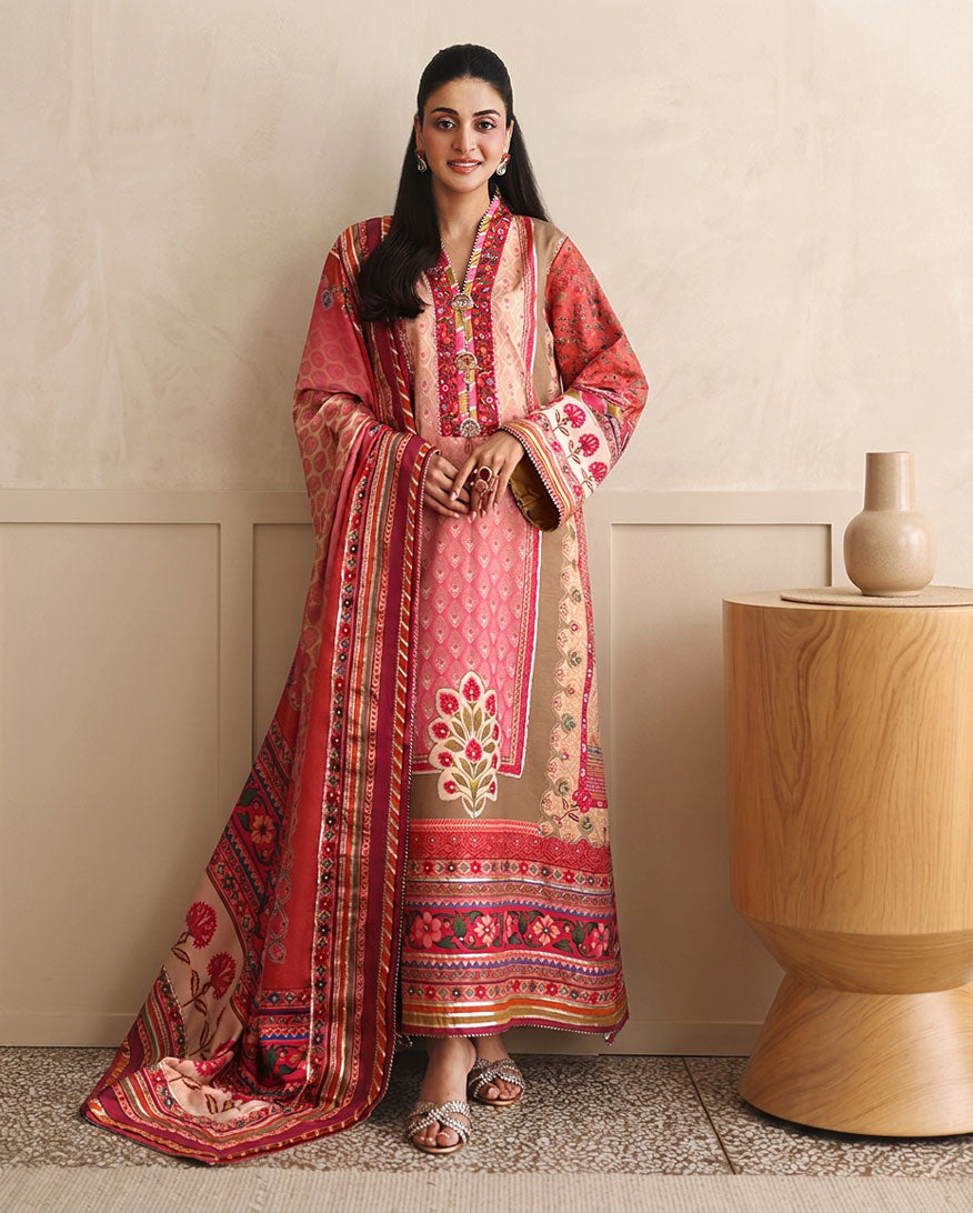 Woman wearing peach printed raw silk suit standing beside a wooden side table