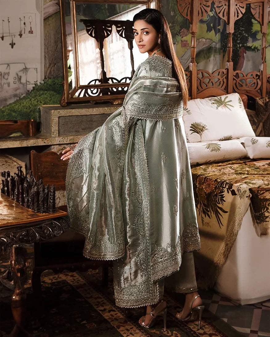 Woman wearing sea green silver zarri silk suit, back view, side profile near chess table