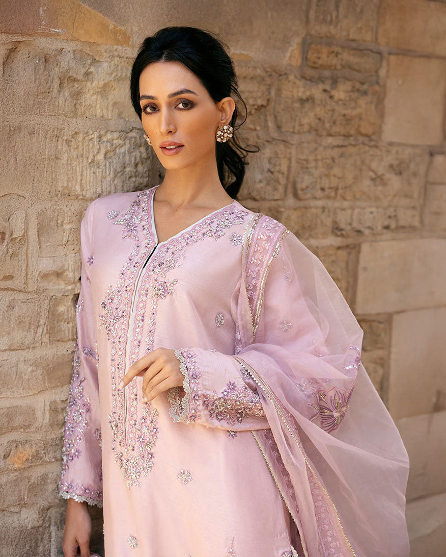 Woman wearing Astrid pink raw silk suit with resham embroidery and cutwork lace border dupatta