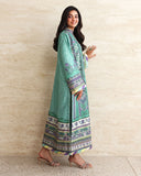 Side view of green printed raw silk suit walking, showing embroidered hem border