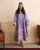 Woman wearing purple printed raw silk suit standing in a wood-panelled room with striped dupatta