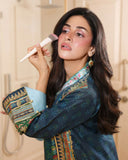 Close-up of embroidered sleeve cuff on blue printed raw silk suit while applying makeup