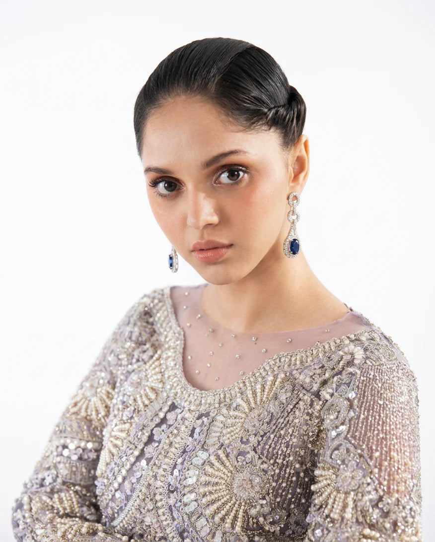 Close-up of the crystal and pearl embellished neckline on a Lilac Net suit