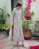 Woman wearing silver embellished satin zari suit, side standing, looking down