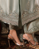 Woman wearing sea green silver zarri silk suit, close-up of embellished hemline and shoes