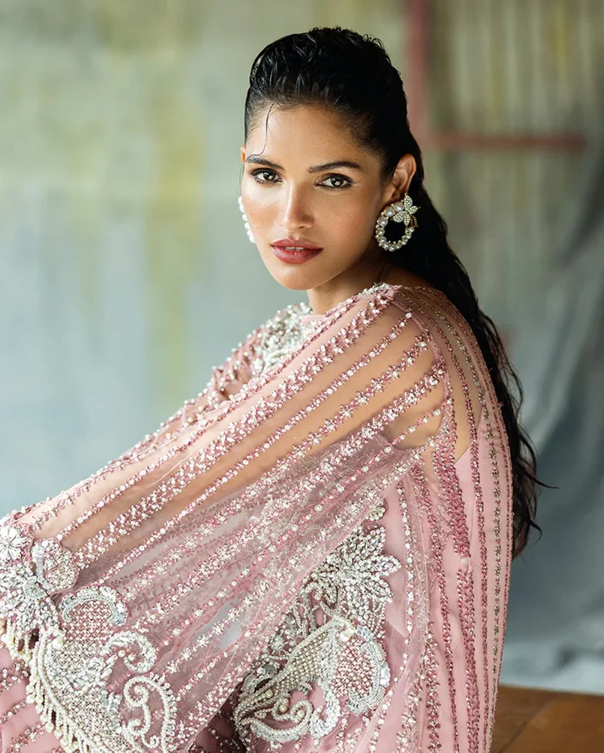 Side profile of a Powder Pink Net suit with embroidered organza dupatta draped over the shoulder