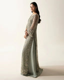Side view of mint green net suit showing draped embroidered cape sleeve and pipe detailing