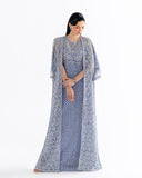 Woman wearing blue embroidered net suit with fringed cape jacket over matching slip dress
