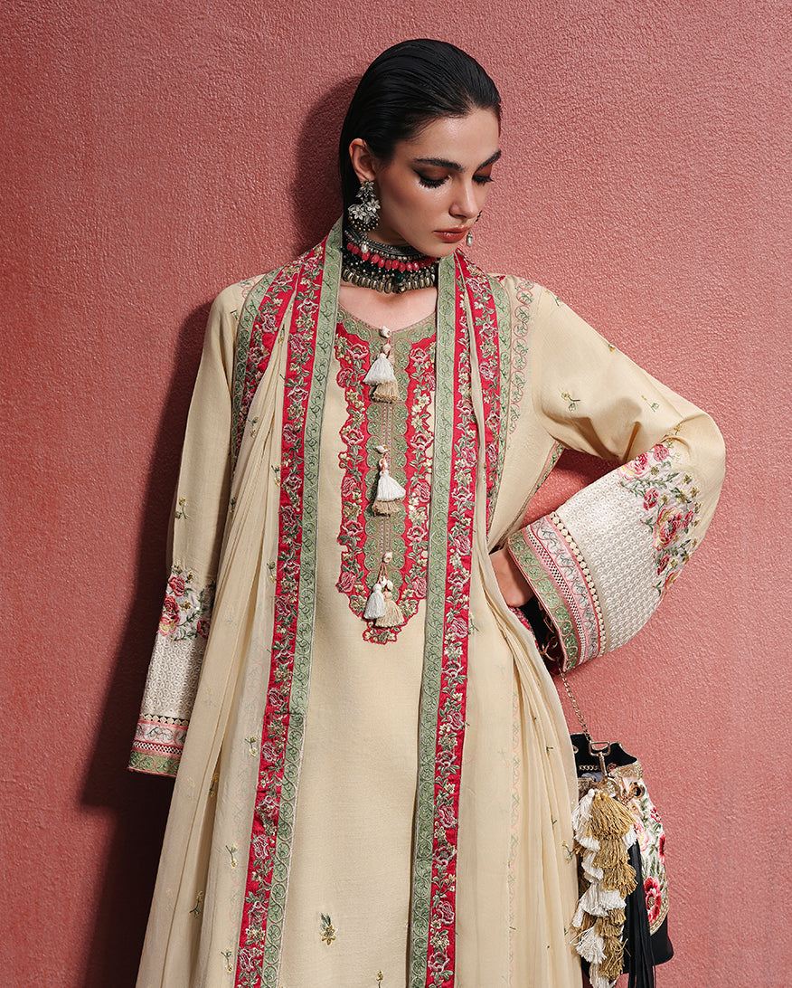 Close-up of hand embellished neckline tassels and embroidered silk border on off white raw silk dress