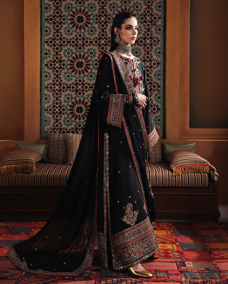 Side view of black raw silk suit showing sequinned sleeve border and embroidered chiffon dupatta