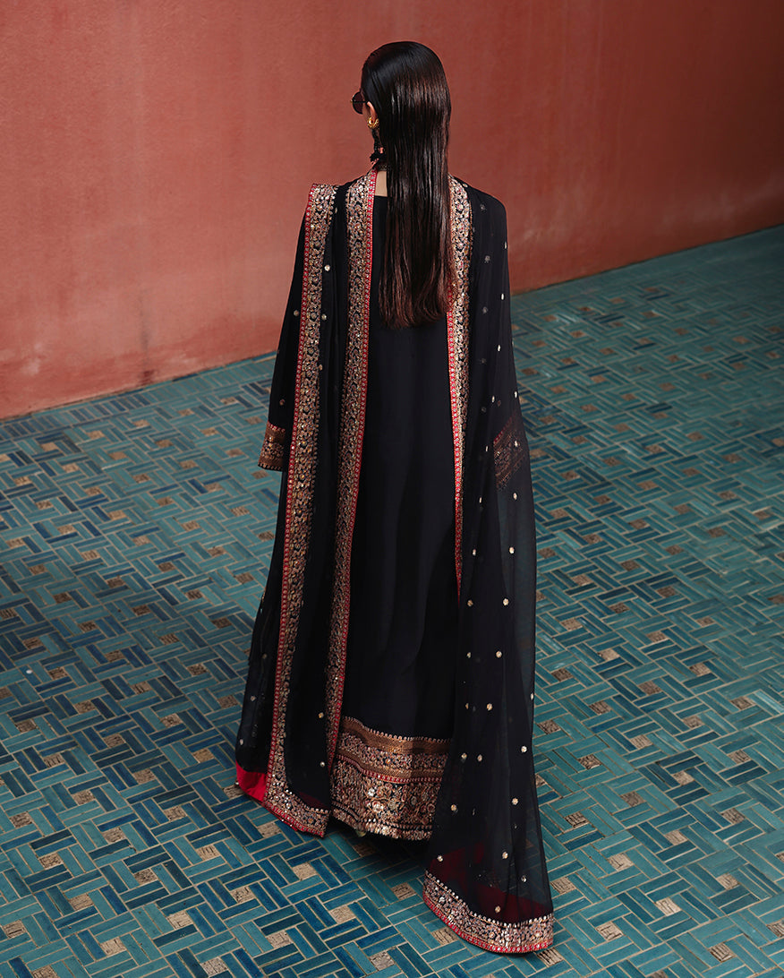 Back view of black raw silk suit with embroidered dupatta draped over both shoulders