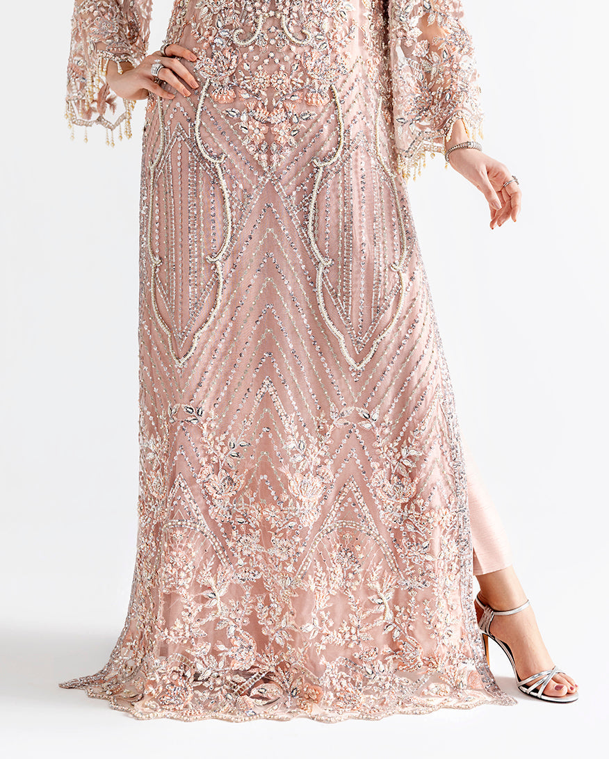 Close up of Woman wearing peach net kaftan with sheer dupatta draped and flowing behind
