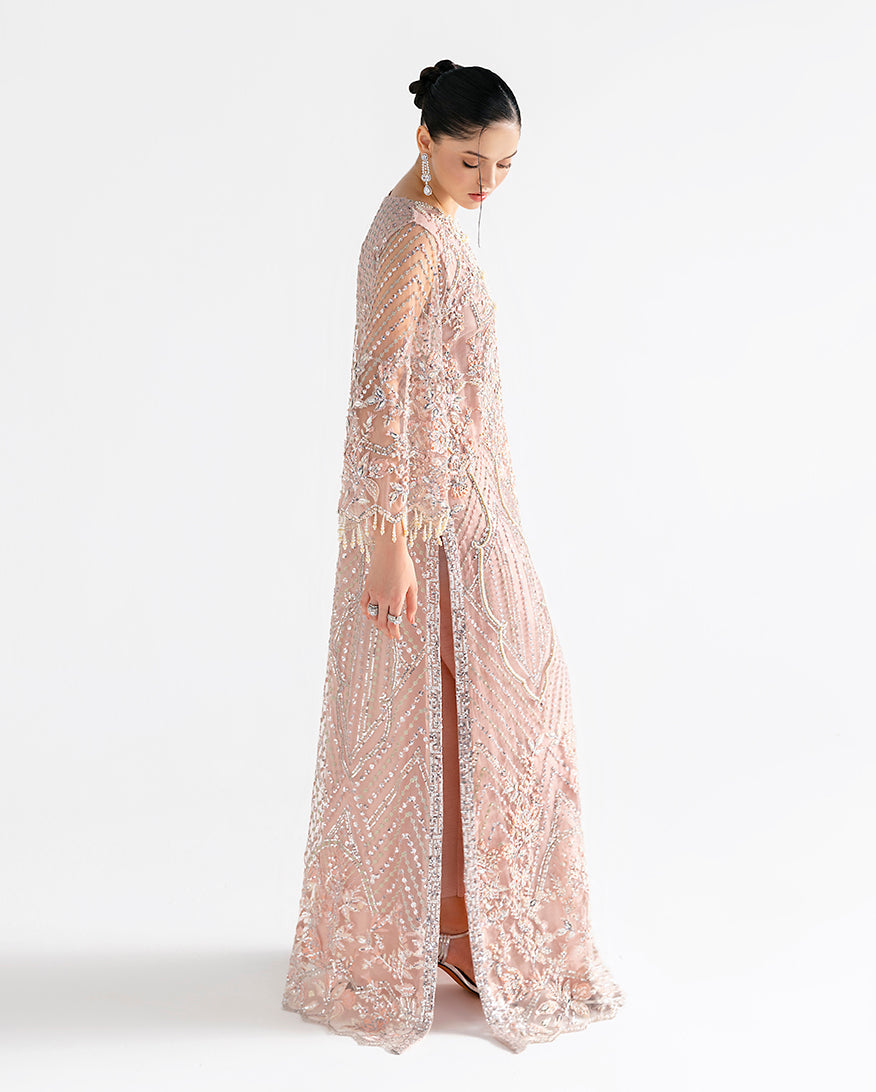 Side view of peach net kaftan showing front slit and embroidered vertical panels