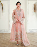 Woman wearing peach pink embellished organza suit, front standing, hands clasped