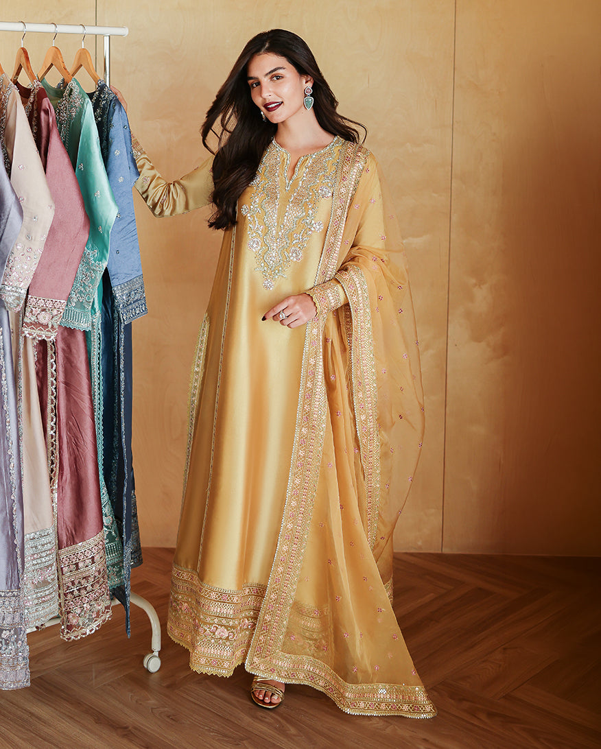 Full-length front view of golden yellow luxury pret suit with embroidered hem, Zarminay collection