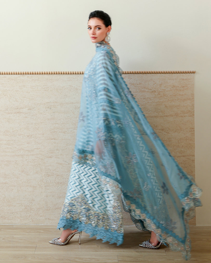Woman wearing Blue brosha suit with organza dupatta draped over shoulder