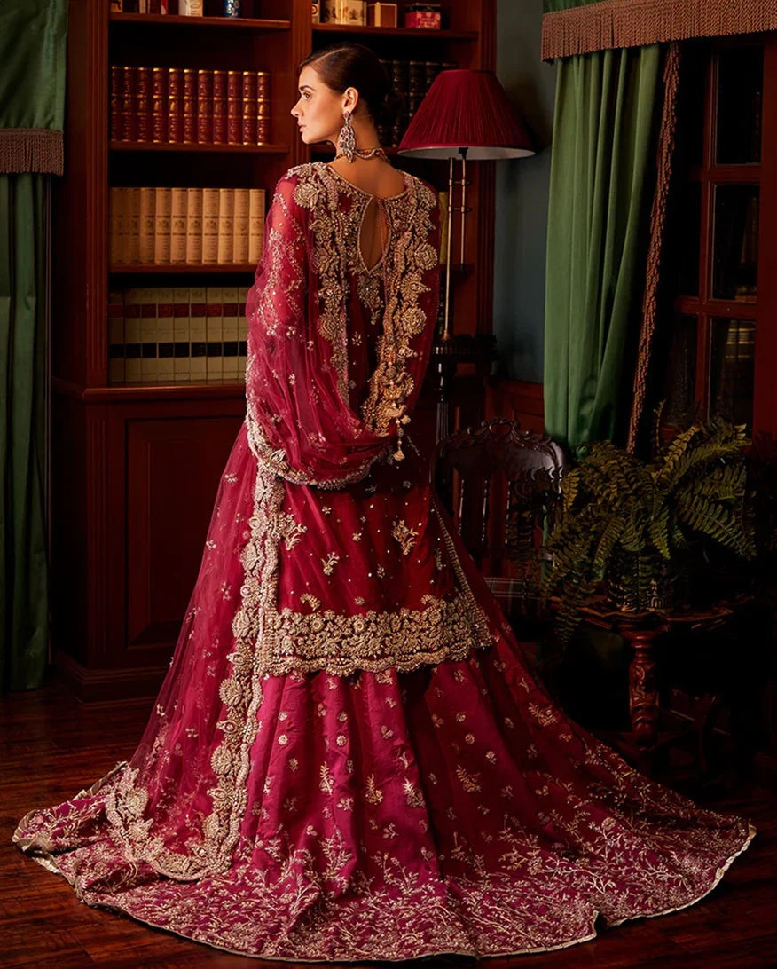 Back view of woman wearing magenta embellished Net bridal lehenga with sheer sleeves