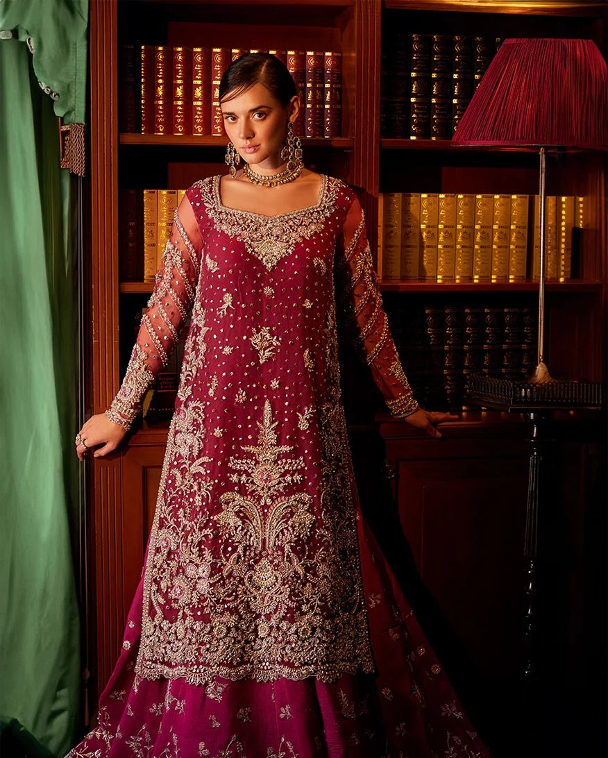 Woman wearing magenta embellished Net bridal gown with sheer sleeves, front view