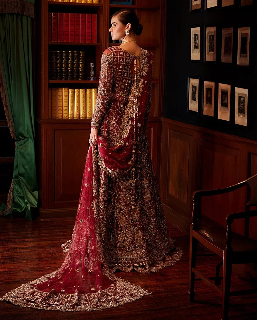 Woman wearing red embellished Net bridal gown with sheer dupatta train, back view