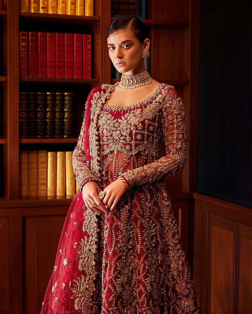 Close-up of woman wearing red Net bridal gown with heavy beadwork on bodice and choker