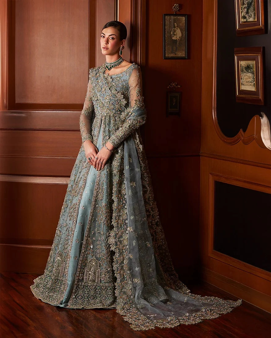 Woman wearing teal blue embellished Net bridal gown with sheer sleeves, front view
