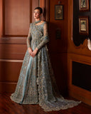 Woman wearing teal blue embellished Net bridal gown with sheer sleeves, front view