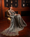Woman wearing teal blue embellished Net bridal gown, seated pose with dupatta train