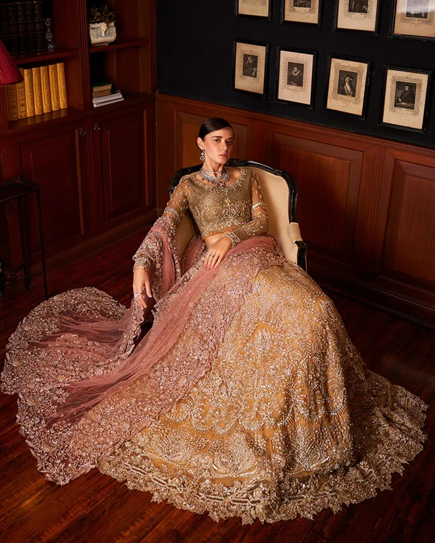 Bride seated in olive gold lehenga with blush dupatta pooling across the floor