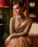 Close-up of embellished bridal bodice with sheer sleeves and layered statement necklace