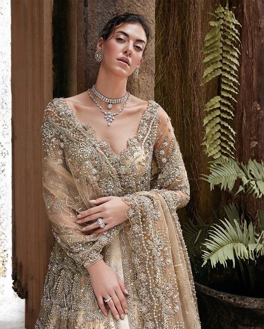 Woman wearing a Beige Net bridal dress with layered jewelry, one of Mushq's pakistani designer bridal dresses
