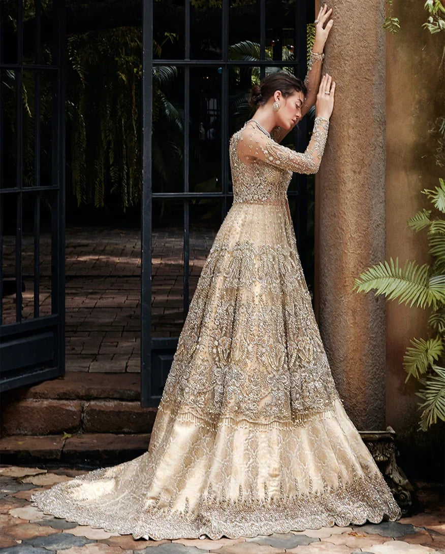 Woman in a Beige Net walima bridal dress, side pose with tiered embroidered skirt