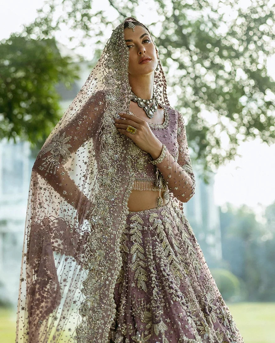 Woman wearing Purple Net lehenga choli with sheer embroidered dupatta, a walima bridal dress by Mushq