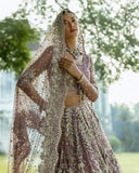 Woman wearing Purple Net lehenga choli with sheer embroidered dupatta, a walima bridal dress by Mushq