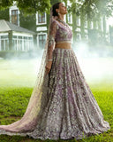 Woman in Purple Net lehenga choli with floral embroidery, one of Mushq's pakistani wedding dresses