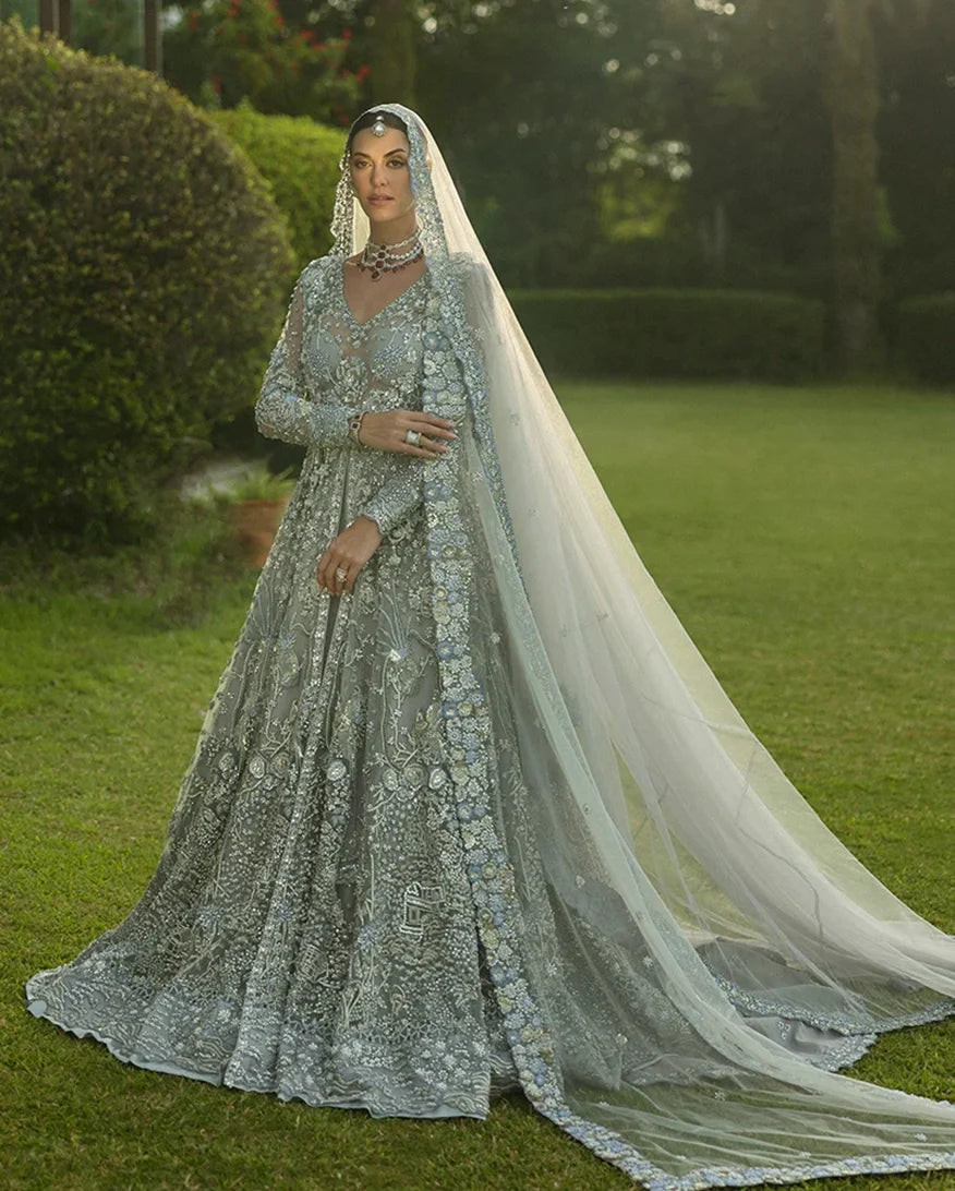 Woman wearing an Ice Blue Net bridal dress with floral embroidery, a bridal dress brand in Pakistan